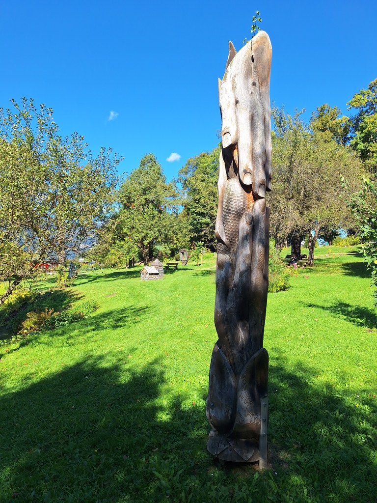 Dřevěný totem a poupě před věží farního kostela svatých Petra a Pavla - Sochařský park Irdning - 18. 9. 2025 - Foto: Jiří Provazník